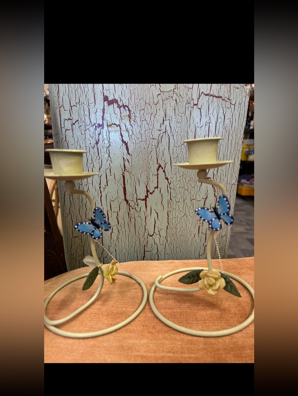 set metal candlestick holders with yellow flowers and blue butterfly accents.